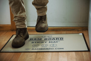 Boots walking on ram board sticky mat